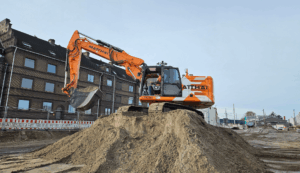 Bagger mit SDX-Compact von Sodex Innovations auf einem Hügel mit Erde