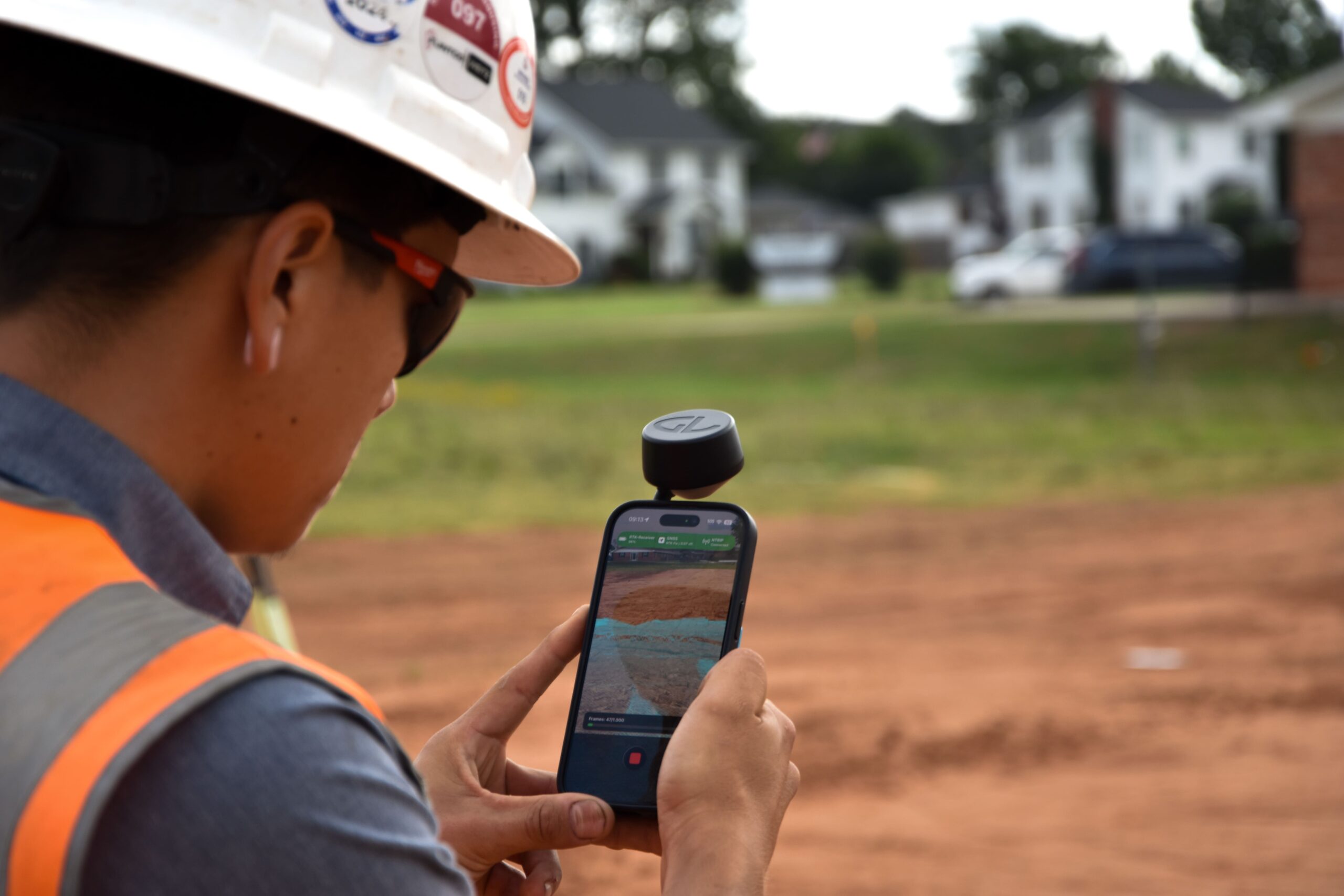 Man using SDX-PocketScan on his iPhone with photogrammetry scanning on an earthmoving construction site to get the as-built data of the terrain.