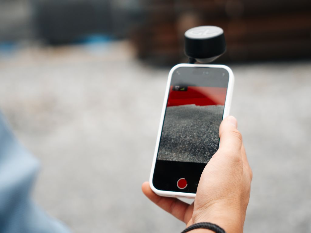 Smartphone mit 3D-Scan-Anwendung und GNSS-Empfänger im Außeneinsatz