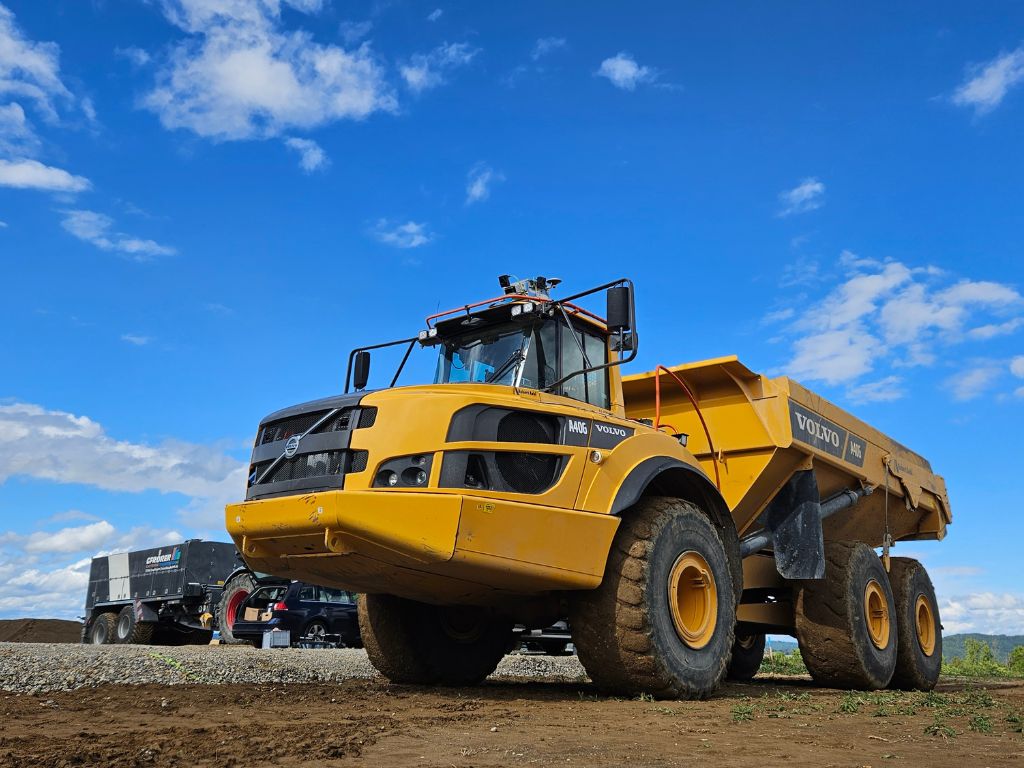 Gelber Volvo-Kipplaster auf Erdbaustelle bei blauem Himmel im Einsatz