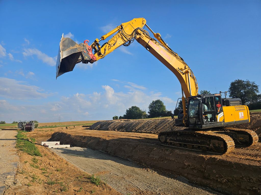 Kettenbagger hebt Erdreich für Pipelinebau auf freiem Feld aus